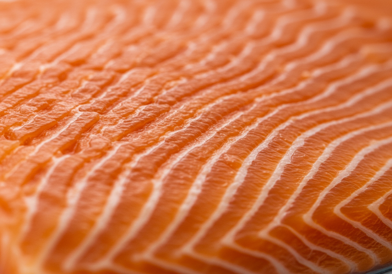 Close-up of raw salmon fillet showing the texture and color, highlighting its freshness.
